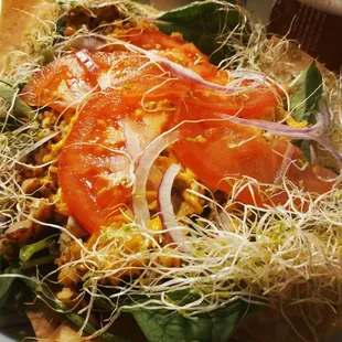 a salad with tomatoes and sprouts
