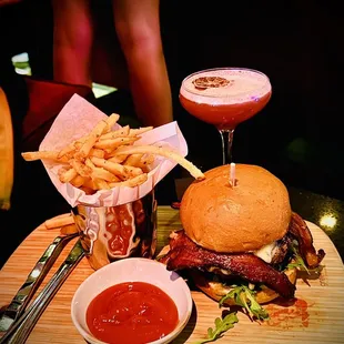 Wagyu Burger with crispy bacon, heirloom tomato, truffle Gouda, arugula, huckleberry spread, and pickles with truffle fries
