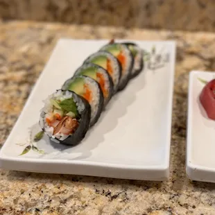 two plates of sushi on a granite countertop