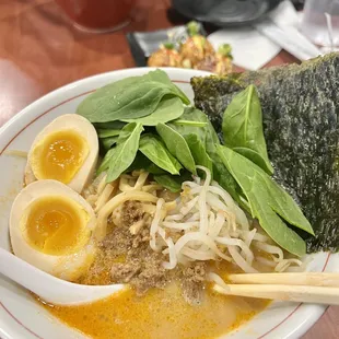 a bowl of ramen with an egg and spinach