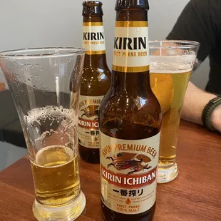 two bottles of beer and a glass of beer