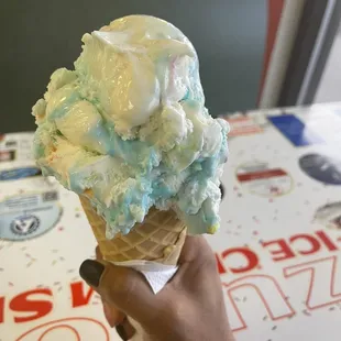 a hand holding a cone of ice cream
