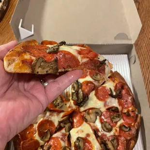 Slice of pepperoni and mushroom pizza