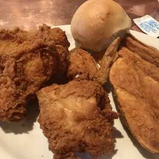 Italian chicken dinner with potatoes wedges and dinner roll