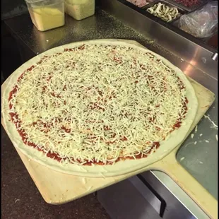 In the process of making a 24" GIANT Cheese Pizza.