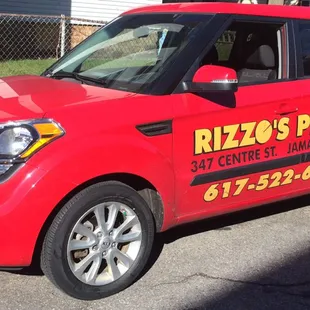 a red car parked in front of a house