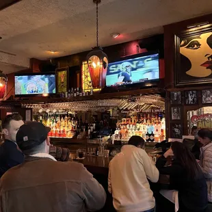 people at a bar watching tvs