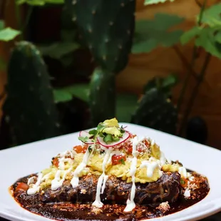 Mole Enchildas. Topped with your egg of choice, sour cream, and pico de gallo.