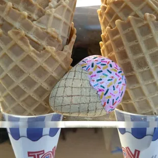 two ice cream cones with sprinkles and a donut