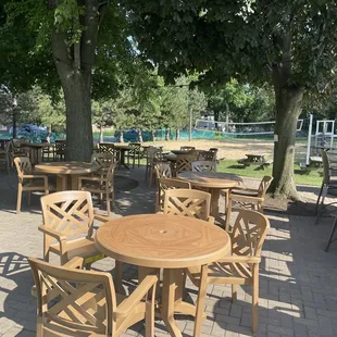 tables and chairs under a tree