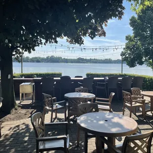tables and chairs on a deck overlooking a lake