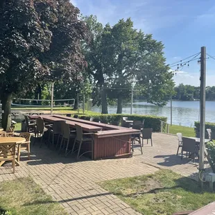 tables and chairs on a patio overlooking a lake