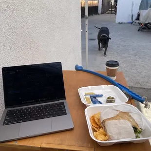 Eating takeout while exercising the dog and doing some light work.  Tasty sandwich.  Side of Jalapeños were a bonus.