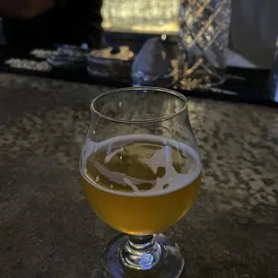 a glass of beer on a bar