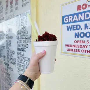a hand holding a cup of ice cream