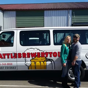 a man and woman standing in front of a van