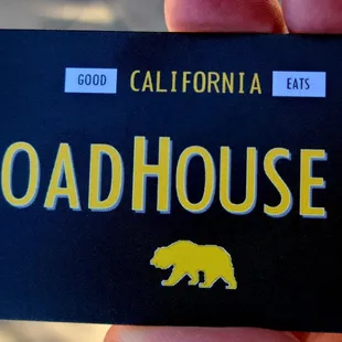 a hand holding a roadhouse 48 sign