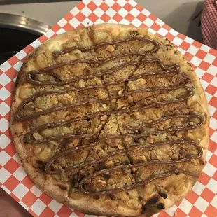 a hand holding a pizza