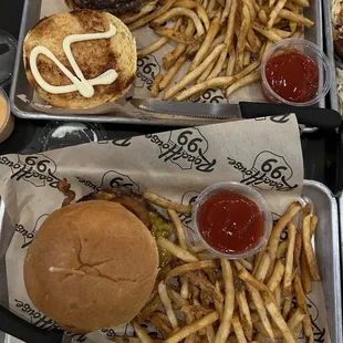 two trays of burgers and french fries