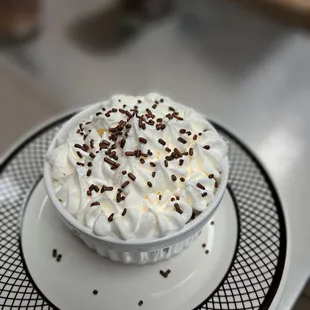 a cup of hot chocolate with whipped cream and chocolate sprinkles