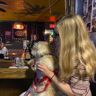 a woman sitting at a bar with a dog