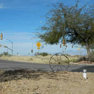 an old wagon wheel on the side of the road