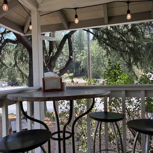 a table and stools on the porch