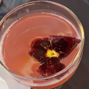 a glass of wine with a flower in it