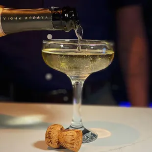 a bottle of wine being poured into a wine glass
