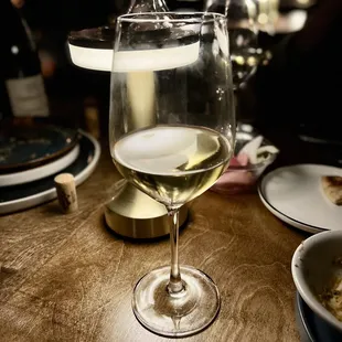 a glass of white wine on a table