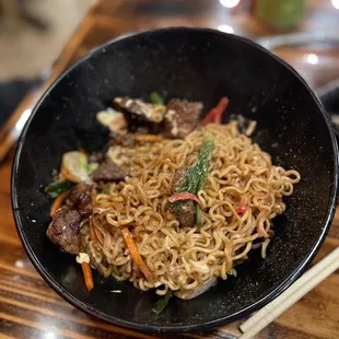 a bowl of noodles and chopsticks
