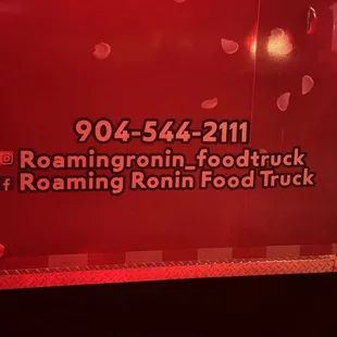 a red food truck with the name of the restaurant