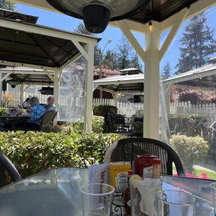 a patio with a table and chairs and a fan