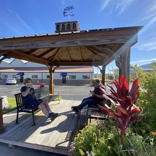 two people sitting on a bench under a gazebo