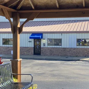 a woman sitting on a bench in front of a restaurant