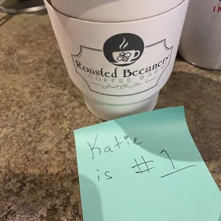 a cup of coffee and a note
