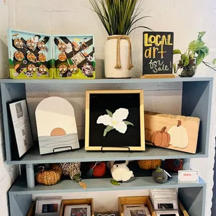 a shelf with books, magazines, and a plant