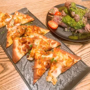 a plate of pizza and a plate of broccoli