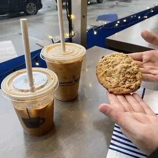 Iced oat milk cortado (front) , iced oat milk latte (back), and an oatmeal raisin cookie
