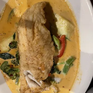 a bowl of soup with a fish fillet