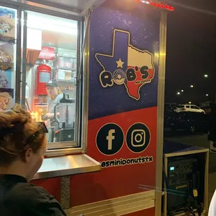 a man and a woman standing in front of a food truck