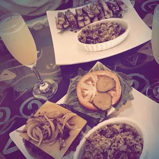 Cheeseburger with a side of jambalaya. Background is seared tuna with side(s) jambalaya and already eaten salad-Not in photo.
