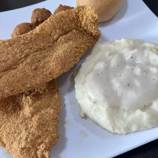 Catfish fillets, mashed potatoes and gravy, hush puppies and roll.