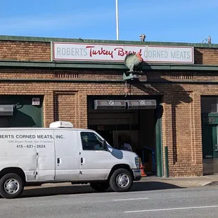 a white van parked in front of a brick building