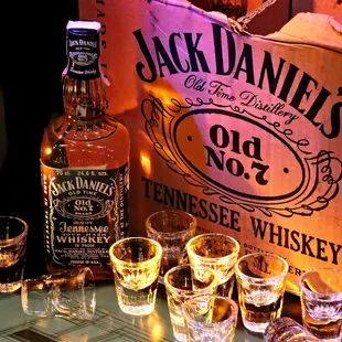 a bottle of jack daniel&apos;s tennessee whiskey and shot glasses