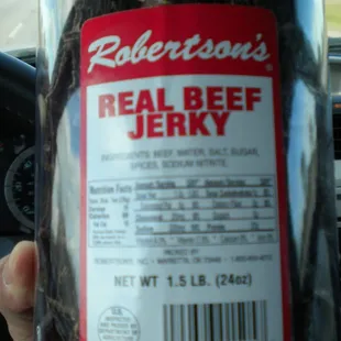 a hand holding a bottle of real beef jerky