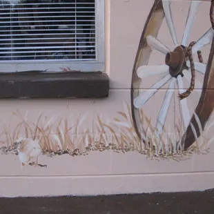 an old wagon painted on the side of a building