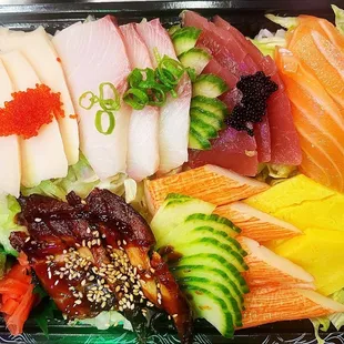 a variety of sushi in a plastic container