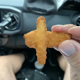 a hand holding a piece of fried food