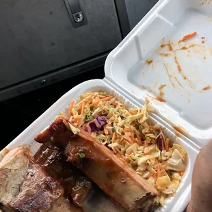 ribs and coleslaw in a styrofoam container